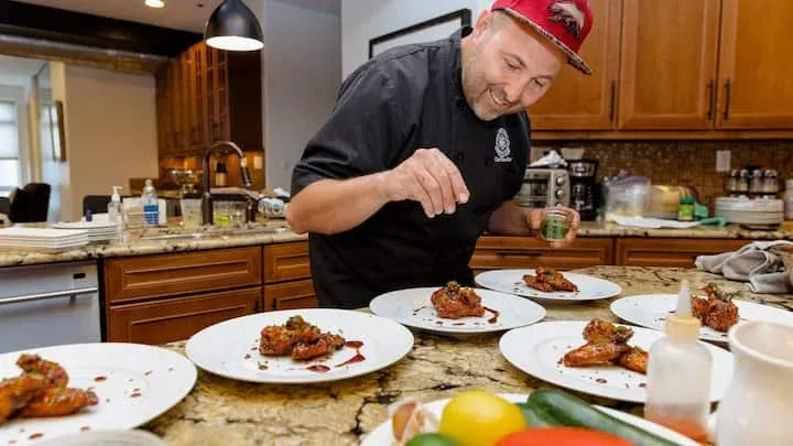 Chef Roilty preparing dishes with guests at a cooking class