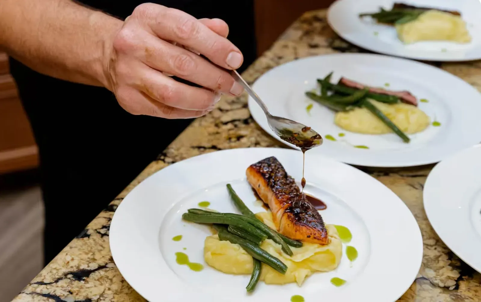 Chef plating salmon for a traditional private chef dinner in Denver
